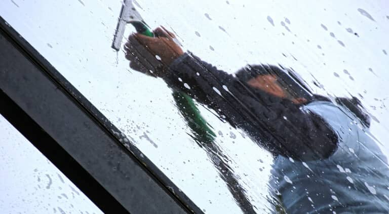 człowiek myje okno
